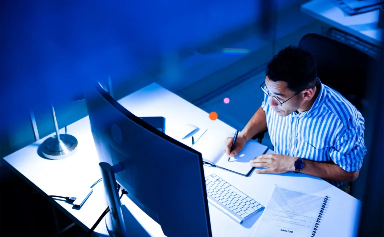 An image showing a man looking at chargeback data at his computer